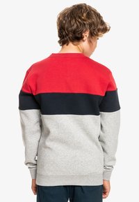 Sudadera color bloqueada en rojo, azul marino y gris, con mangas largas, tejido de mezcla de algodón, cuello redondo y puños y dobladillo de canalé.
