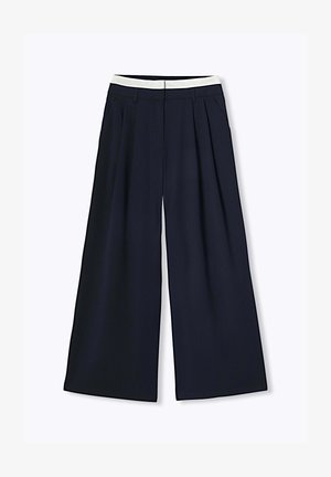 Pantalon large bleu marine avec fines rayures et une ceinture blanche contrastante, doté de passants pour ceinture et de plis avant.