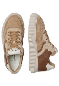 Baskets en suède et tissu beige avec des accents texturés, bout rond et semelle en caoutchouc contrastante. Présente un bloc de couleurs beige et marron.