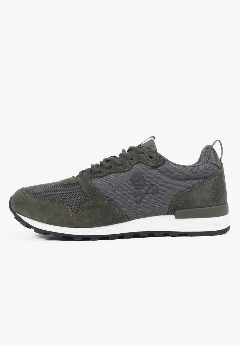 Baskets de sport pour hommes avec une tige en suède vert foncé et un tissu texturé gris, une semelle intermédiaire blanche et un accent de logo crâne sur le côté.