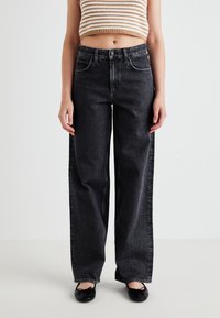 Sorte bukser med bred benvidde lavet af denim med en falmet tekstur. Har en knaplukning, frontlommer og kontraststing langs sømmene.