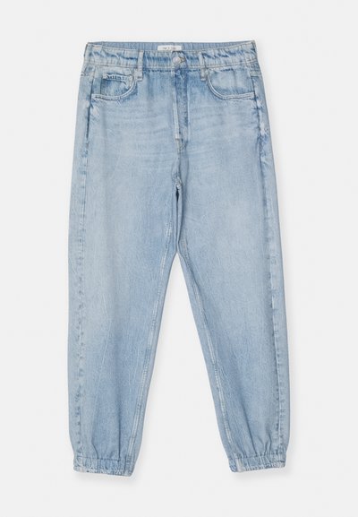 Ανοιχτό μπλε τζιν παντελόνι με ελαστική ζώνη, στενές γάμπες και μπροστινές τσέπες. Το ύφασμα έχει απαλή, υφασμένη επιφάνεια.