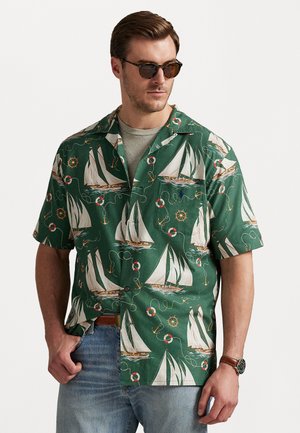 Short-sleeve green shirt featuring a nautical sailboat pattern. Made of fabric with a smooth texture and a relaxed fit.