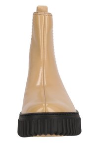 Bottine en vernis beige avec une finition lisse, des panneaux latéraux élastiques, une semelle en caoutchouc noir striée, et un design à bout rond.