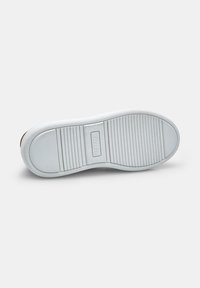 Talpa din cauciuc alb pentru adidași, texturată cu striuri orizontale și verticale, având o placă logo rectangulară în centru.