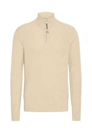 Beež villane sviiter kõrge kaeluse ja veerand-zipp disainiga. Omab soonikuid mansette ja hemmi, tekstuurset kangast ning minimaalset detailide kasutust.