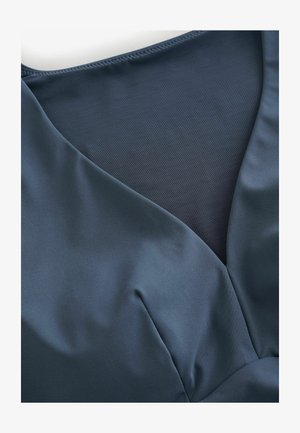 Tume sinine V-kaelusega riideese, millel on sile kangas ja läbipaistev võrkkangast paneel kaeluse all, näidates tekstuuri kontrasti.