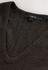 Brauner Pullover mit Struktur, V-Ausschnitt und gerippten Kanten. Verfügt über ein schwarzes Etikett mit der Marke "NEXT" in der Nähe des Kragens. Weiches Strickmaterial.