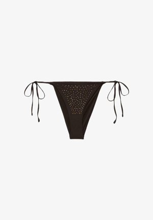 Bas de bikini noir avec des liens latéraux à nouer et de petites clous dorés disposés en motif triangulaire sur le panneau avant.