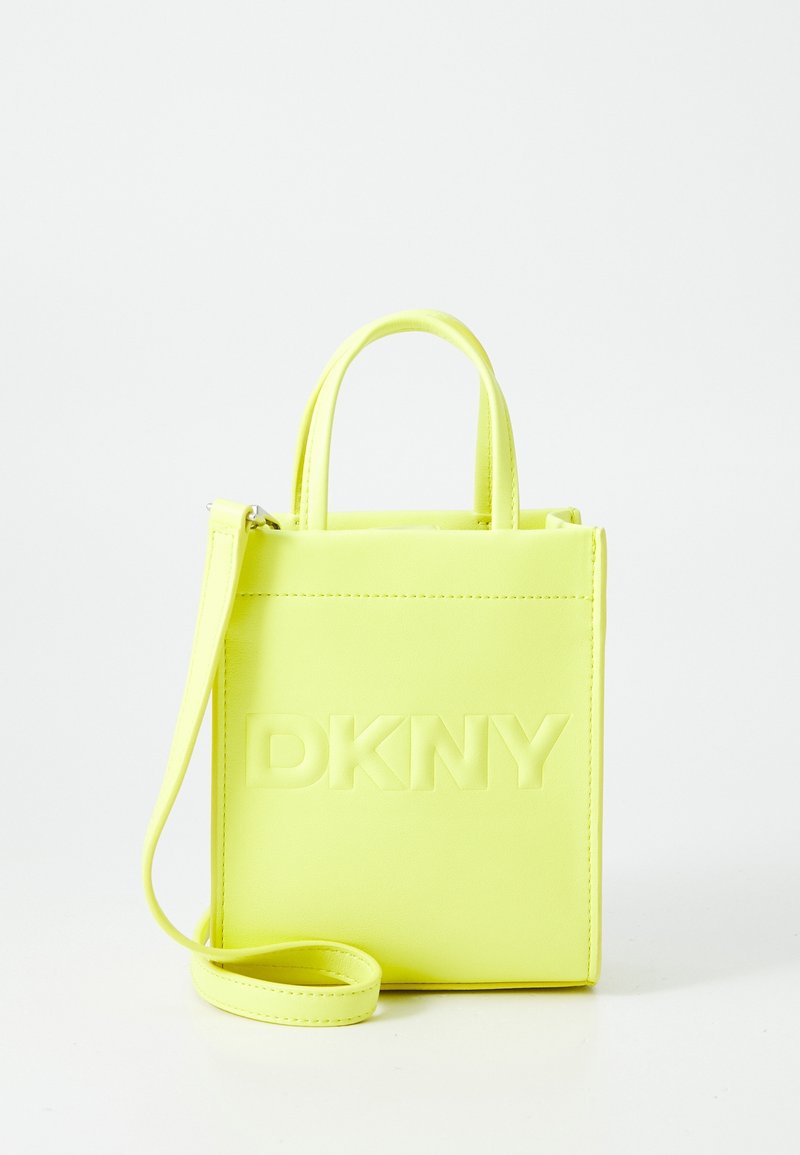 Sac en cuir jaune avec logo "DKNY" embossé, forme carrée, poignées courtes et bandoulière amovible. Texture lisse, design minimaliste.
