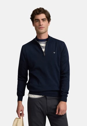 Suéter de cremallera en algodón suave de color navy, con cuello alto, puños y dobladillo acanalados, y un logo sutil en el pecho.