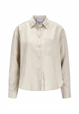 Camicia button-up beige chiaro realizzata in tessuto morbido, con colletto, maniche lunghe, una tasca sul petto e orlo arrotondato.