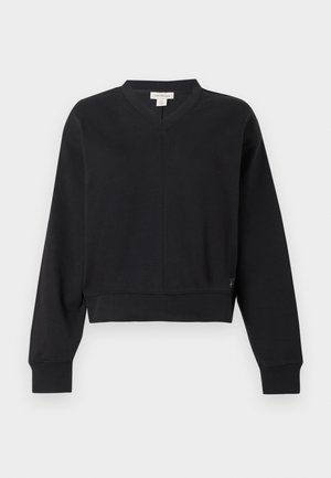 Svart kort collegegenser med V-hals, lange ermer, ribbestrikkede mansjetter og en flat sømdetalj foran og bak. Mykt materiale.