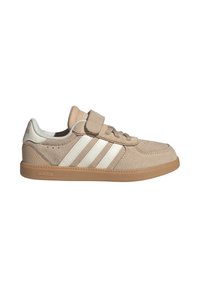 Baskets Adidas en daim beige avec bandes blanches, semelle en gomme, lacets et large bande Velcro sur le dessus pour la fermeture.