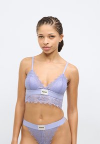 Lillat värviline pitsist bralett laineservadega ja logoga vööga, millele on lisatud sobivad stringid sarnase pitsimustriga ja logoga vöö.