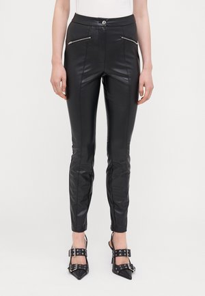 Black faux leather pants with a slim fit, featuring zippered pockets and visible stitching. The pants have a smooth texture and a high waist.
