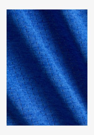 Blåt stof med en tekstureret mønster af små perforeringer og diagonale folder, der skaber skygger og højlys.