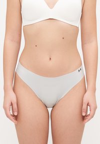 Lichtgrijze onderbroek met een gladde, glanzende textuur, met een laag uitgesneden ontwerp en een klein zwart logo aan de linkerkant.