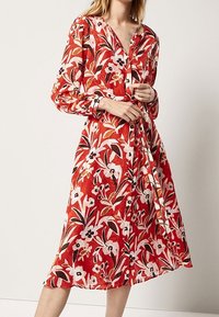 Robe midi florale rouge en tissu léger, dotée de manches longues, d'une fermeture boutonnée à l'avant et d'une ceinture à nouer à la taille.