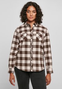 Camicia a quadri marrone e crema con due tasche sul petto, collo e maniche lunghe. Tessuto morbido con una vestibilità comoda.