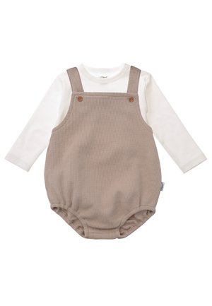 Beige checkered romper with adjustable straps and wooden button details, paired with a long-sleeve white top underneath. Soft cotton fabric.