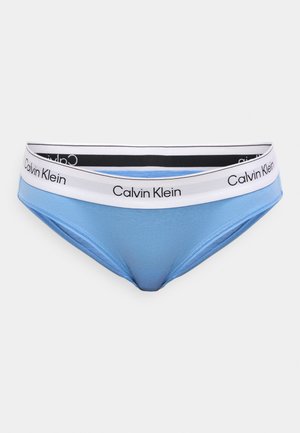 Blue underwear with a smooth texture and a contrasting white waistband featuring "Calvin Klein" branding in black. Classic, low-rise design.