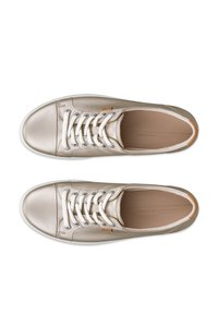 Paire de baskets en cuir beige à lacets, semelles blanches, bouts arrondis et étiquettes de logo marron sur fond blanc.
