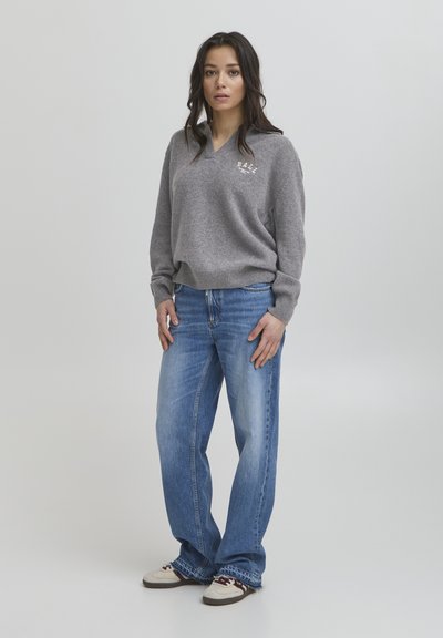 Gray knit sweater with a v-neck and 'BALL' text. Worn with light blue wide-leg jeans and beige sneakers with dark accents.