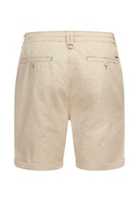 Beige cotton shorts with a smooth texture, folded cuffs, two back pockets, and a button closure at the waist.