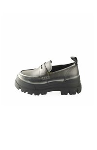 Black leather slip-on shoe with a rounded toe, featuring a thick textured rubber sole and a raisedback heel tab for easy wear.