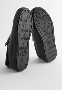 Pantofi negri slip-on cu parte superioară din plasă texturată și talpă din cauciuc. Talpa are un profil cu un model pentru aderență. Mărimea este marcată ca 46/40.