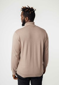 Beige gebreid pullover met een hoge kraag, ribgebreide manchetten en zoom. Heeft een gladde textuur en een aansluitende pasvorm, geschikt voor het dragen in lagen.