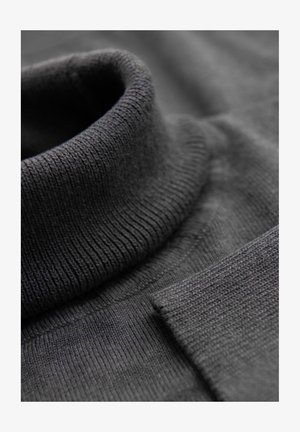 Czarny sweter z golfem o ribbowanej fakturze, z dopasowanym kołnierzem i gładkim materiałem. Zbliżenie ukazuje detale i przeszycia.