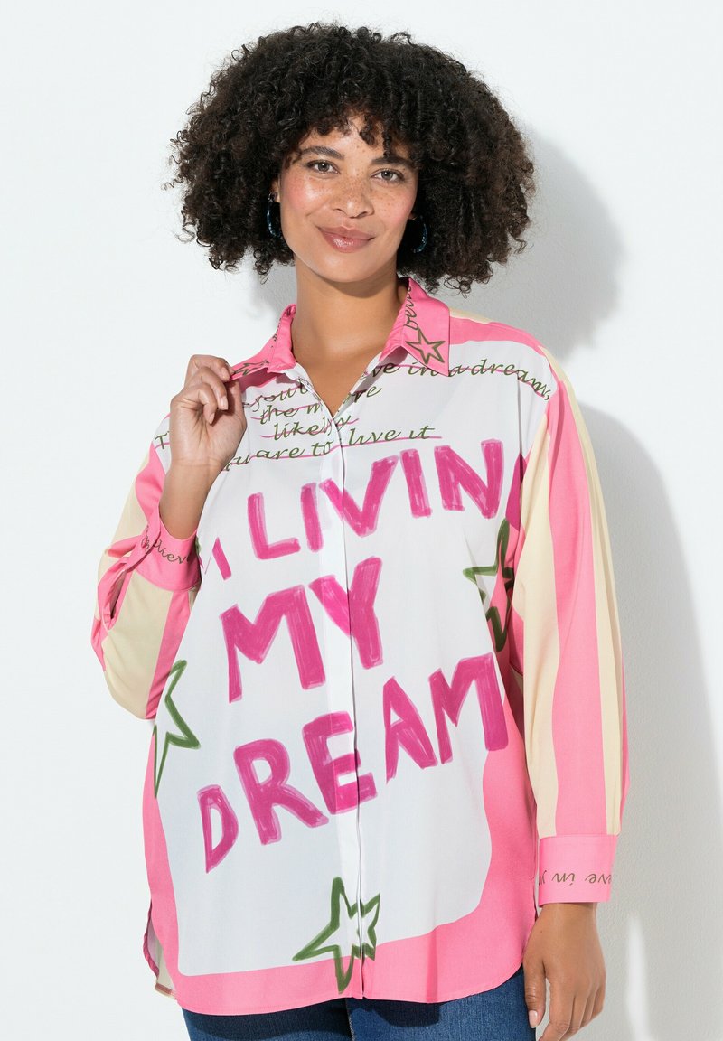Kolorowa, oversized koszula z guzikiem w białym kolorze z różowymi i zielonymi akcentami. Posiada wzory z tekstem i gwiazdkami. Długie rękawy i kołnierzyk.