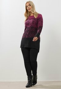 Fioletowo-czarna sweter z melanżem, długimi rękawami, okrągłym dekoltem i bocznymi rozcięciami; zestawiony z czarnymi spodniami typu slim i czarnymi botkami za kostkę.
