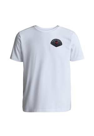 Hvid T-shirt med korte ærmer og rund hals samt sort skjoldformet logo med rød hånd og teksten "ZAVETT" på venstre bryst.