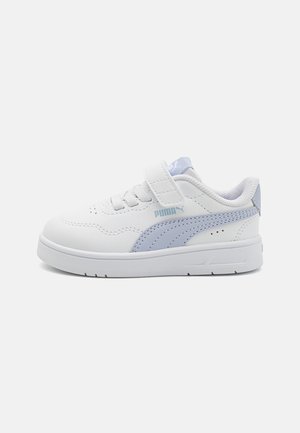 Zapatillas blancas con textura suave, que presentan detalles en azul claro, una correa de Velcro y el logo de Puma en el lateral y la lengüeta. Suela de goma plana.