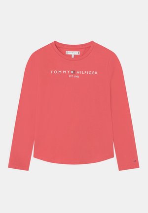 Koralowa koszula z długim rękawem i okrągłym dekoltem, z białym napisem "Tommy Hilfiger EST. 1985" oraz logo na piersi.