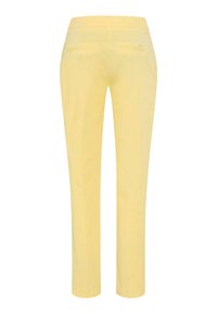 Gule, tætsiddende bukser set bagfra med to paspolerede lommer og bæltestropper.