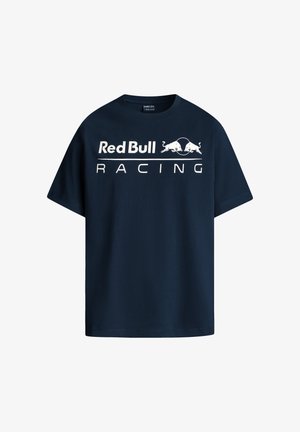 Tumedast sinine puuvillane T-särk, millel on valge tekst "Red Bull Racing", lühikesed varrukad, ümmargune kaelus ja lõtv istuvus.
