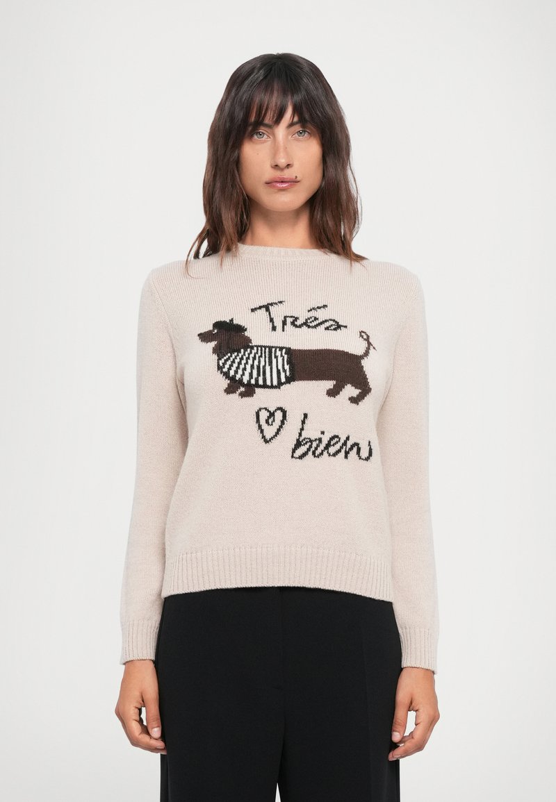 Beige knitted sweater featuring a brown dachshund graphic with a striped scarf, and text reading “Trés bien” in black. Ribbed cuffs and hem.
