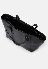 Black leather tote bag with zipper closure, featuring dual handles and a textured surface. Spacious interior with no visible compartments.