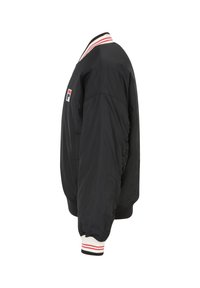 Chaqueta bomber negra con cuello y puños acanalados que presentan rayas rojas y blancas. Incluye un pequeño parche con el logo en la manga izquierda.