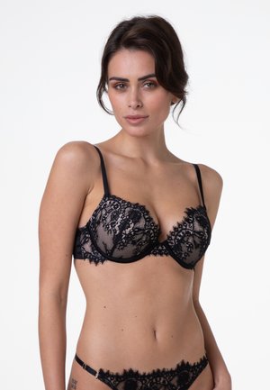 Reggiseno in pizzo nero con stecche e spalline regolabili, caratterizzato da intricati motivi floreali e tessuto semitrasparente, impreziosito da dettagli in satin.