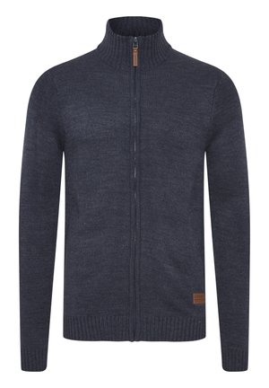 Mornarsko plava pletena džemper s visokim ovratnikom, punom duljinom zatvarača, rebrastim manžetama i rubom. Kožni akcent tag u donjem lijevom kutu.