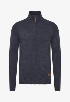 Navyblauwe gebreide trui met een hoge kraag, volledige ritssluiting, geribde manchetten en zoom. Leren accentlabel aan de onderlinkerkant.