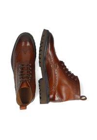 Brązowe skórzane buty brogue z sznurowanym fasonem, dekoracyjnymi perforacjami, solidnymi gumowymi podeszwami i pętelkami na piętach ułatwiającymi zakładanie.