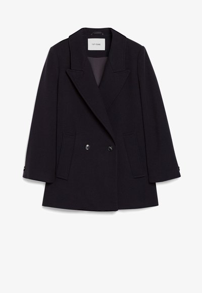 Διπλής όψης μάλλινο παλτό σε σκούρο ναυτικό χρώμα με καλλιεργημένο γιακά, τσέπες με καπάκι και μανσέτες με έναν κουμπί. Υφασμάτινη υφή με δομημένη εφαρμογή.