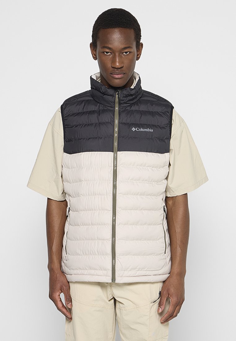 Gilet puffo bianco e nero con colletto alto, zip frontale e tasche laterali. Presenta il logo Columbia sulla parte superiore sinistra.