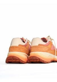 Zapatillas en tonos naranja, beige y rosa; materiales de ante y malla con una suela de goma texturizada; logotipo "HOFF" en el talón; diseño de cordones.